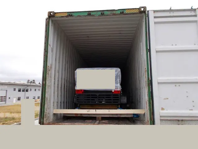 Wrapped cargo braced inside an open container, with identifying details covered